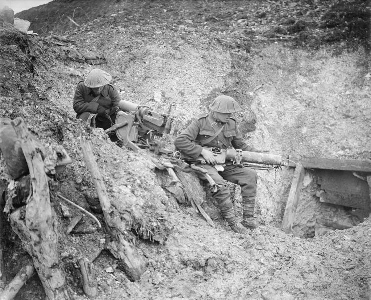 Two soldiers of the 8th (Service) Battalion, North Staffordshire Regiment examine captured machine guns outside a badly damaged German dugout at Beaucourt-sur-Ancre.