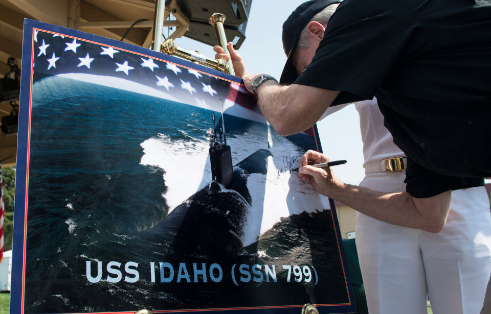 Ray Mabus signs a graphic representation of the future Virginia-class attack submarine USS Idaho (SSN 799) during its ship-naming ceremony at the West Idaho state fair.