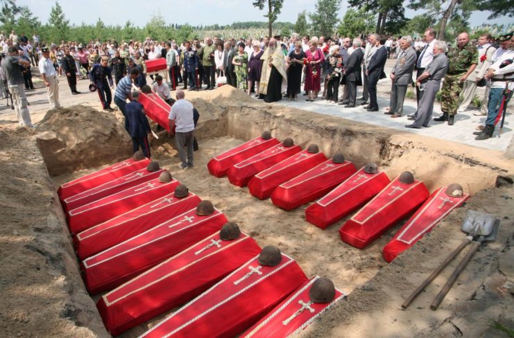 Red caskets containing the remains of WWII Cossack soldiers in a reburial grave in Ukraine