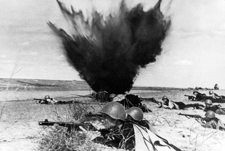 Dismounted Cossack soldiers during a battle in 1942, with an explosion in the background