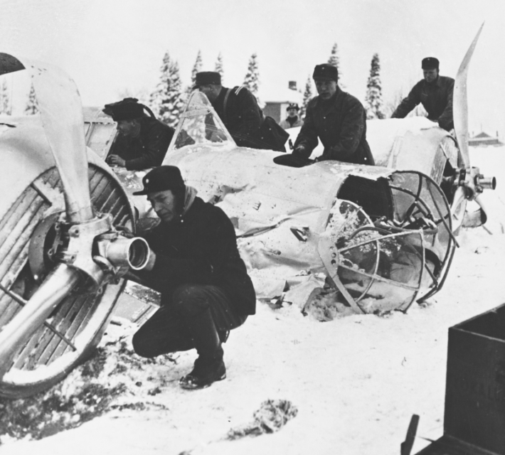 Finnish anti-aircraft crew inspect the wreckage of a twin-engine Soviet bomber brought to earth in one of Soviet raids on Finland.