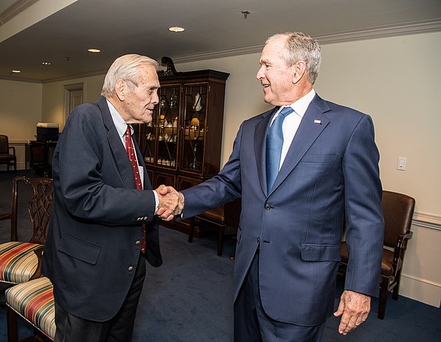 Rumsfeld and former President George W. Bush shaking hands