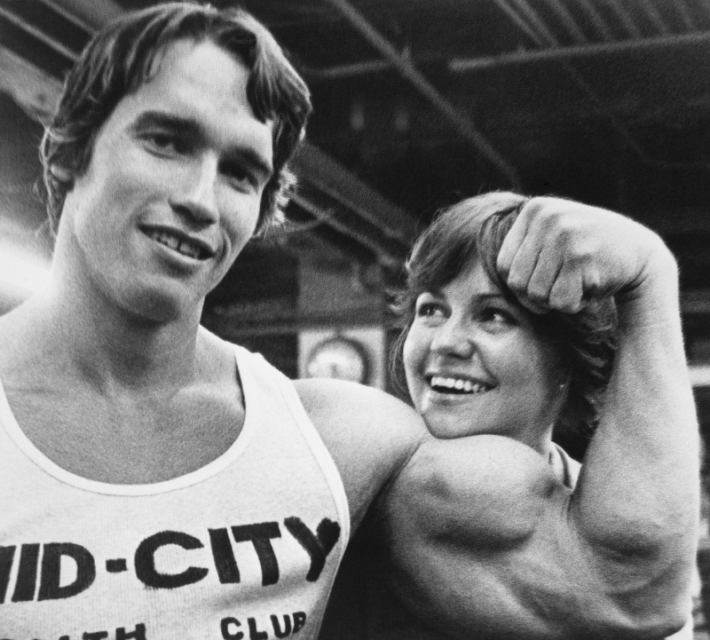 Celebrities Arnold Schwarzenegger and Sally Field pose for photo, Arnold curling his biceps