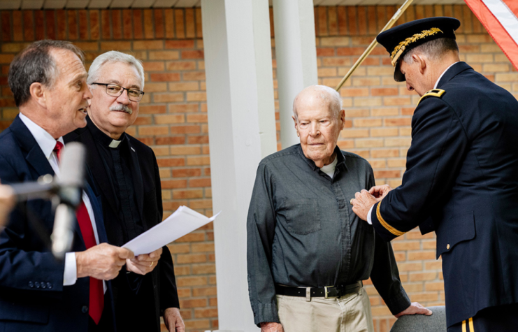 Medal being pinned to Father Ed Flaherty, S.J.