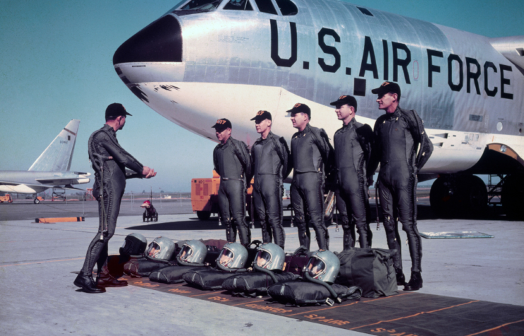 Ground crew performs maintenance on a giant Boeing B-52 stratofortress.