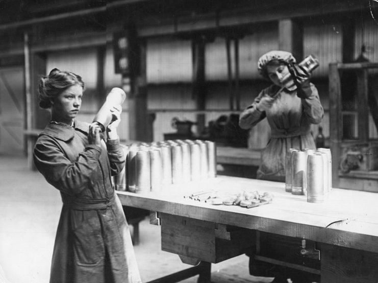 Two women working with shell cases