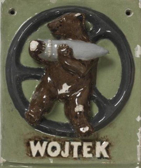 Ceramic pin of a bear holding an artillery shell