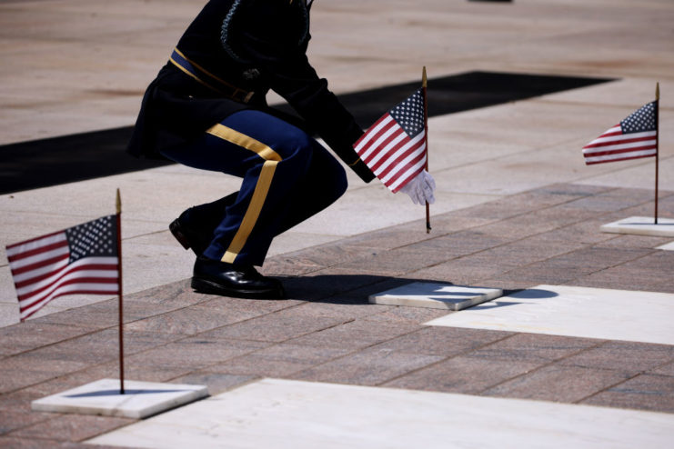 Sentinel kneeling before miniature American flags