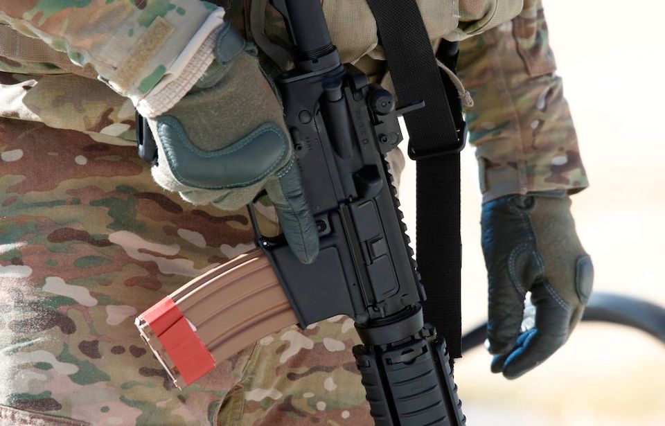 Close up of a National Guard soldier holding a rifle by his side