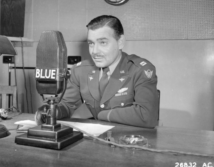 Clark Gable sitting before a microphone