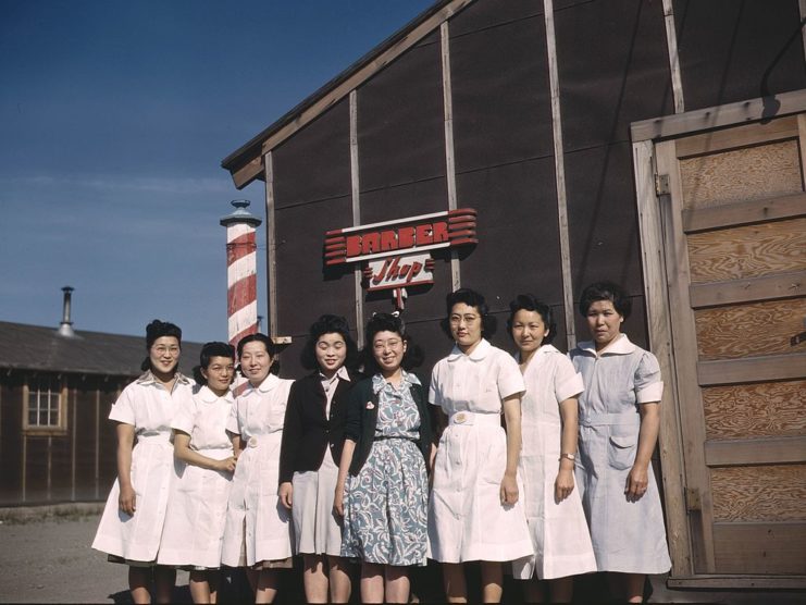 Eight women of Japanese heritage standing in front of a barber shop