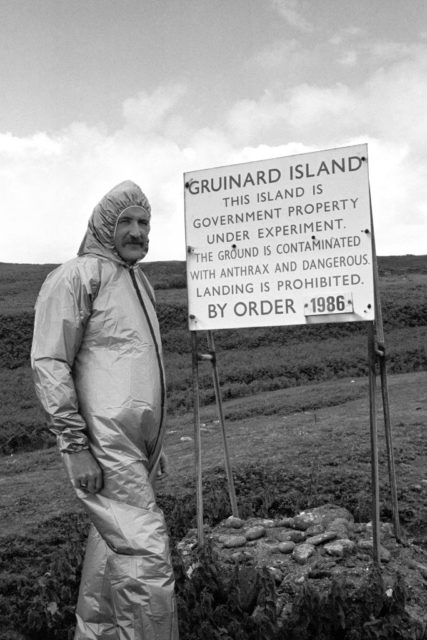 Malcolm Broster alongside one of the warning signs on Gruinard Island