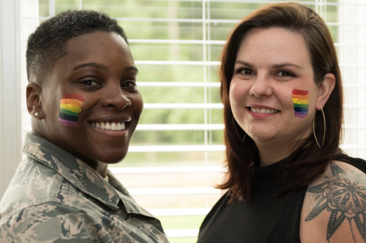 Air Force Master Sgt. Staci Cooper and Danie Cooper with Pride Flags printed on their cheeks