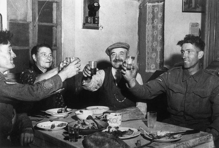 Four men holding up drinking glasses