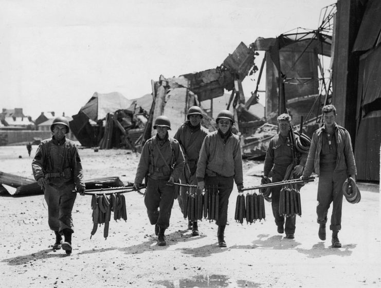 American troops carrying rows of sausage
