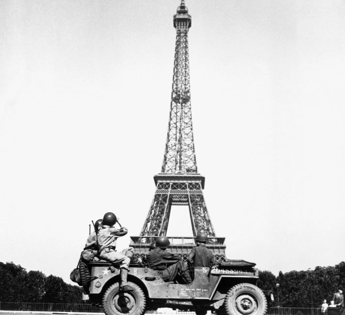 Soldiers with the US 4th Infantry Division driving in front of the Eiffel Tower