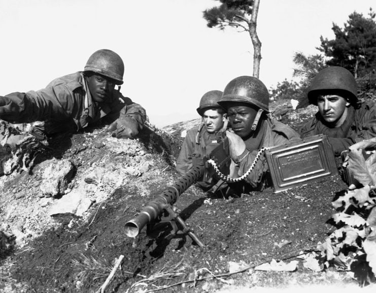 US soldiers holding weapons in a trench