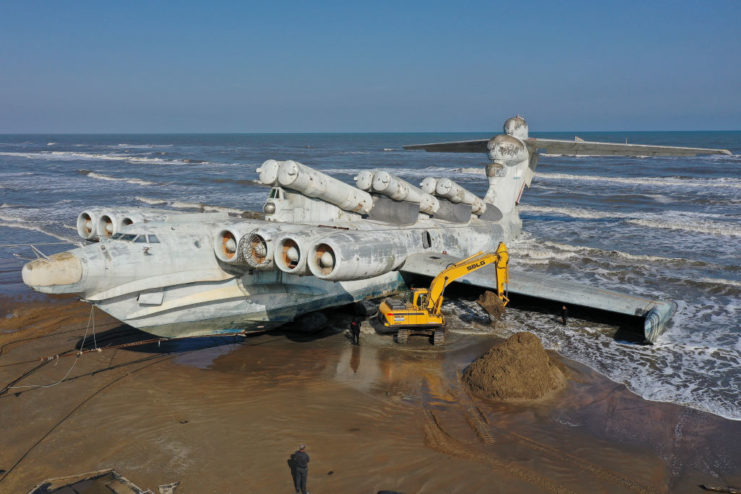 Bulldozer parked beside the Lun-class Ekranoplan MD-160