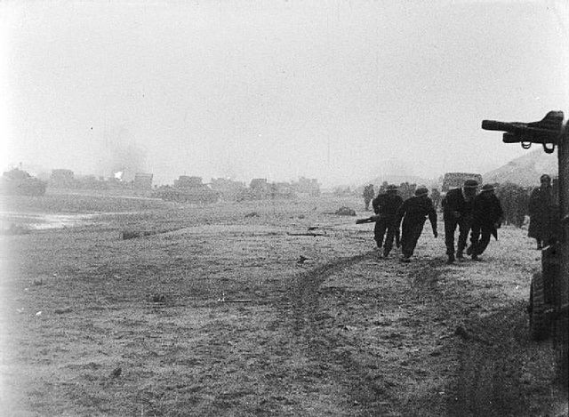Soldiers walking along a beach