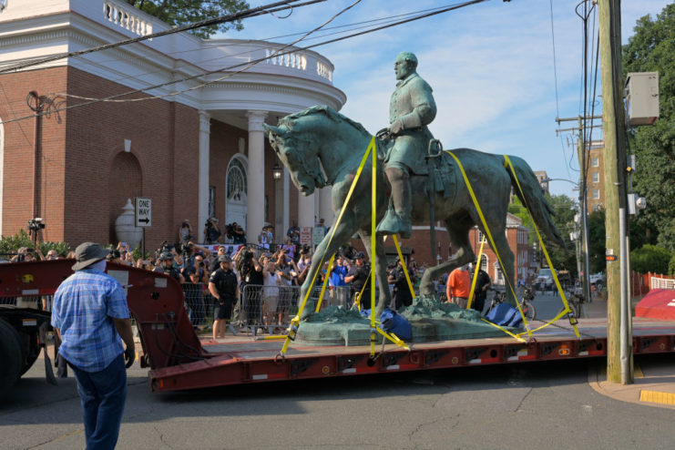 Statue of Robert E. Lee atop a horse strapped to the bed of a truck
