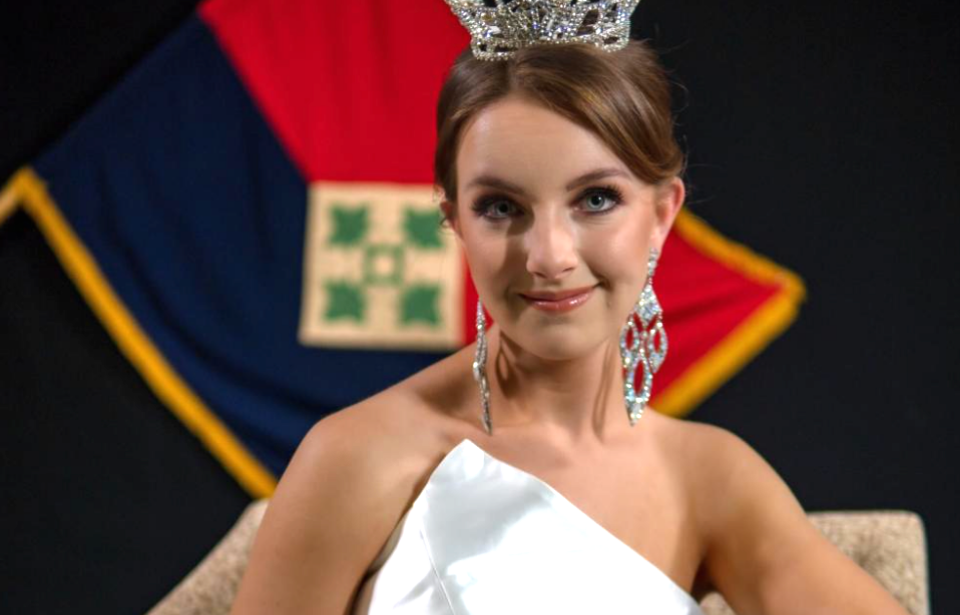 Spc. Maura Spence-Carroll wearing a silver dress and crown