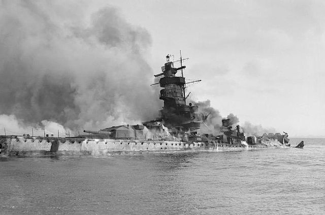 Admiral Graf Spee covered in smoke and flames at sea