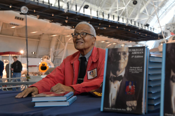 Charles McGe sitting at a table with copies of his book