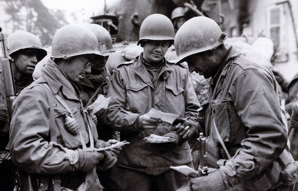 Pfc. Stan Smith, Pfc. Charles Becks, Pfc. Jack Mongold and Sgt. Dominic Renzaglia holding letters