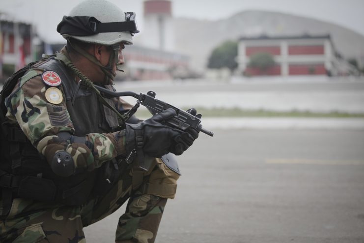 Member of the Argentinian Special Forces crouched down, holding a Micro Uzi