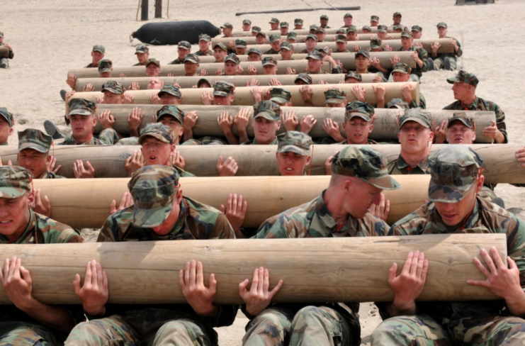 Navy SEAL trainees holding logs