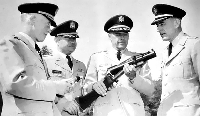 Brig. Gen. William F. Ryan, Col. Russell R. Klanderman, Maj. Gen. Dwight E. Beach and Maj. Gen. William K. Ghormley examining an M79 grenade launcher