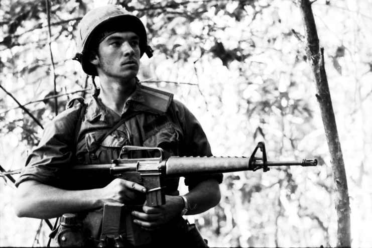 A GI on patrol in Vietnam hold an M-16