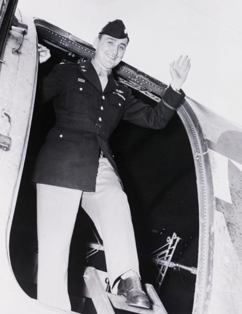 Francis Gabreski waving from the door of an airplane.