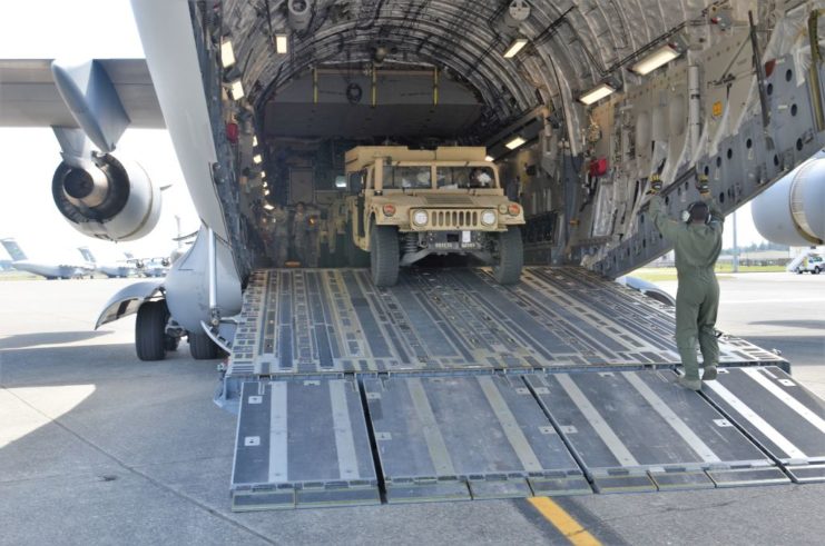 US Air Force loadmaster moving a Humvee onto a airplane 