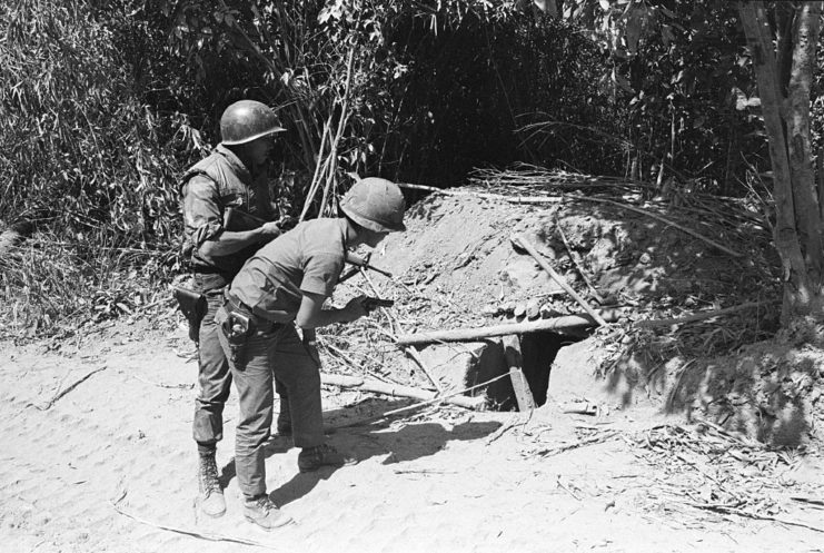 Vietnamese soldiers peering into a bunker