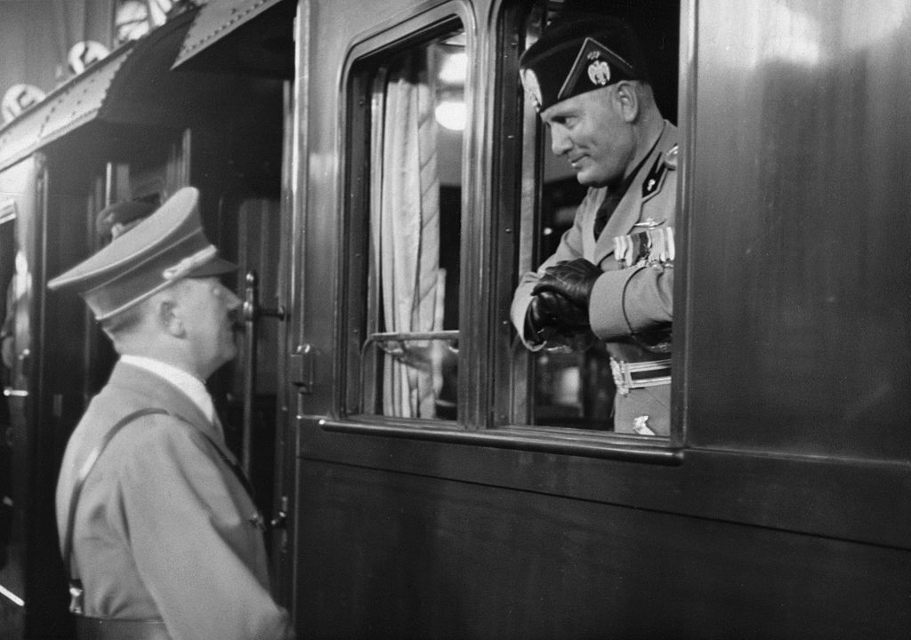 Benito Mussolini and Adolf Hitler have a conversation at a train station in 1937