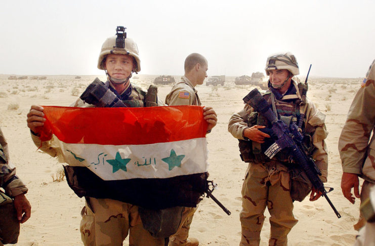 US infantry corporal holding the Iraqi flag