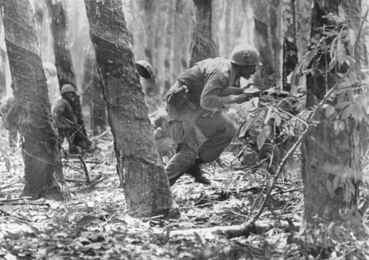 Troops with the 1st Infantry Division running through the jungle