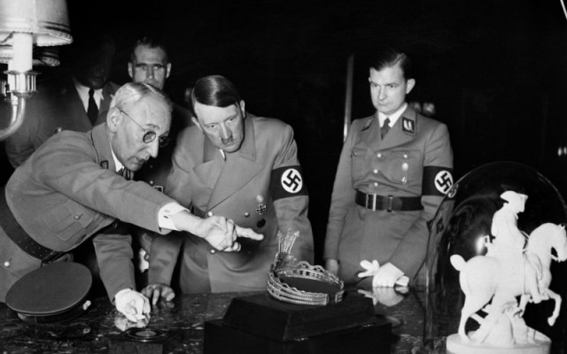 Hitler looking over a cultural object with Nazi colleagues. The dictator had long fancied the idea of a "Super Museum". (Photo Credit: AFP/Getty)