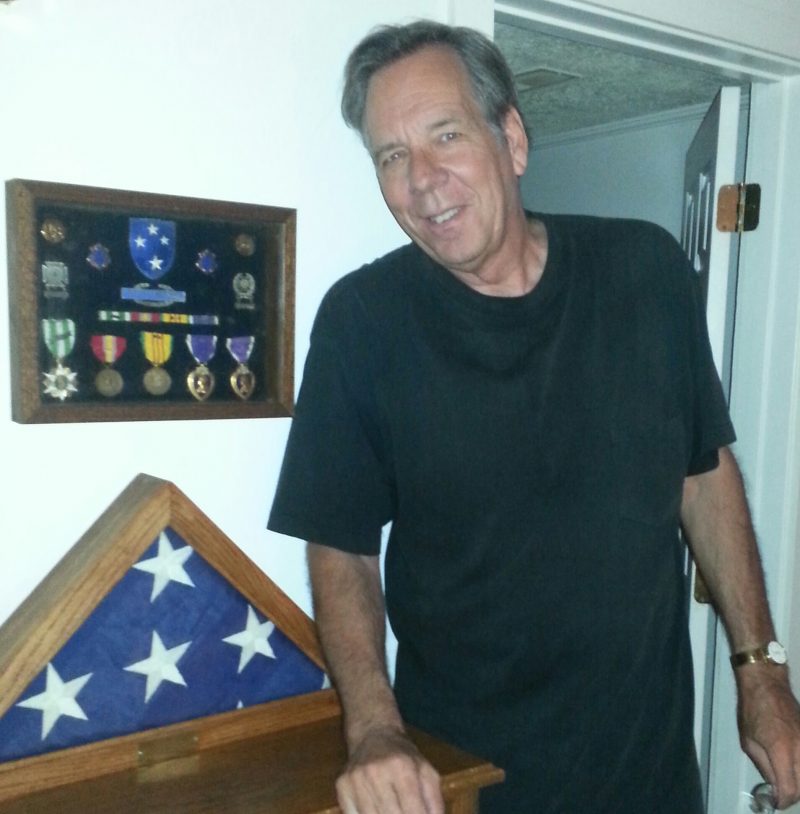 Dick Woods was drafted into the Army in 1969 and served as an infantryman in Vietnam. He is pictured above with his medals—including two Purple Hearts—and the flag he received at his father’s funeral. Courtesy/Jeremy P. Ämick  