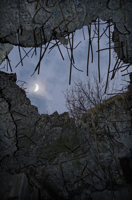 Peering at the sky through a roof of a pillbox: a layer of reinforced concrete - 1,7 m thick - was torn open by a shaped charge.