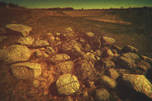 A story of “The Norm”.A pile of stones and some barbed wire, still remembering the summer of 1941.Construction of hundreds of pillboxes of the Molotov Line required huge amounts of stone. It was crushed and mixed with fresh concrete. The best one was coming from the Caucasus Mountains – a long and expensive journey. So, inevitably, local stones were used on a massive scale. But they did not come by themselves. Soviets, as mad and ruthless as they were, were also very precise and rigorous people. Not content with herding thousands of civilians into forced labor zones, they also came up with a set of precise rules, or “norms”, regulating who, how much, when and how was supposed to contribute to the overall effort of “defence works”.It was carefully planned and calculated how many stones each local farmer had to bring to the building site. You've got a horse? Two? If two, then you need to bring more. It was that simple. No horse? You will dig foundation trenches then or, better even, endless anti-tank ditches. There were norms stipulating how many cubic meters of earth one needs to remove and what is the distance that removed portion needs to be moved away.I always go around those remote, small villages asking about anti-tank ditches. As huge as they had been, they are hard to find today, most eaten up by forests and cultivated fields. But every piece of information is precious when drawing the maps of those forgotten strongpoints. I'm always very careful not to overuse the technical and military jargon – these are mostly simple people I talk to. But most often than not I found myself disappointed that they did not understand what I was asking about. It's a simple thing – an anti-tank ditch – even the name implies it, hey, it;s just a damn, deep ditch, that's all about it!And then, to my horror, the answers started to pop out like a devil from the box. Of course they knew what an anti-tank ditch was! I was simply asking a wrong question... They had a different word for an anti-tank ditch. The one they remembered from their fathers and grandfathers, the one which which was so feared as it was hated, the one so horrible it stuck in the minds of simple folk for generations.The called it “the norm”.