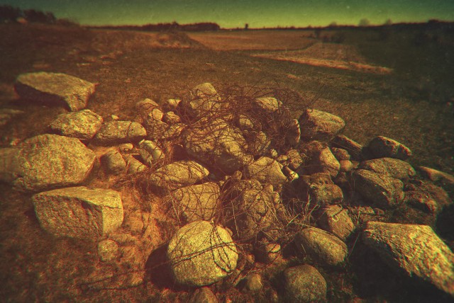 A story of “The Norm”.A pile of stones and some barbed wire, still remembering the summer of 1941.Construction of hundreds of pillboxes of the Molotov Line required huge amounts of stone. It was crushed and mixed with fresh concrete. The best one was coming from the Caucasus Mountains – a long and expensive journey. So, inevitably, local stones were used on a massive scale. But they did not come by themselves. Soviets, as mad and ruthless as they were, were also very precise and rigorous people. Not content with herding thousands of civilians into forced labor zones, they also came up with a set of precise rules, or “norms”, regulating who, how much, when and how was supposed to contribute to the overall effort of “defence works”.It was carefully planned and calculated how many stones each local farmer had to bring to the building site. You've got a horse? Two? If two, then you need to bring more. It was that simple. No horse? You will dig foundation trenches then or, better even, endless anti-tank ditches. There were norms stipulating how many cubic meters of earth one needs to remove and what is the distance that removed portion needs to be moved away.I always go around those remote, small villages asking about anti-tank ditches. As huge as they had been, they are hard to find today, most eaten up by forests and cultivated fields. But every piece of information is precious when drawing the maps of those forgotten strongpoints. I'm always very careful not to overuse the technical and military jargon – these are mostly simple people I talk to. But most often than not I found myself disappointed that they did not understand what I was asking about. It's a simple thing – an anti-tank ditch – even the name implies it, hey, it;s just a damn, deep ditch, that's all about it!And then, to my horror, the answers started to pop out like a devil from the box. Of course they knew what an anti-tank ditch was! I was simply asking a wrong question... They had a different word for an anti-tank ditch. The one they remembered from their fathers and grandfathers, the one which which was so feared as it was hated, the one so horrible it stuck in the minds of simple folk for generations.The called it “the norm”.