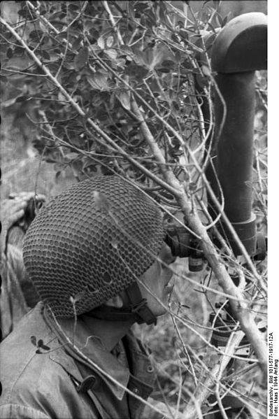 A paratrooper looking at the battlefield through a periscope.