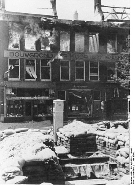 A Dutch defensive position, houses burn in the back because of the German Bombing.