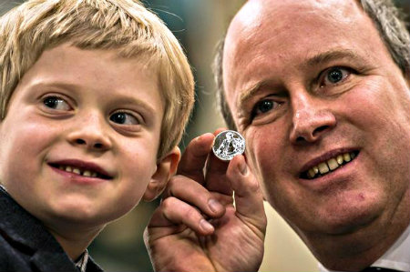 Sir Winston Churchill's great-grandson, Randolph, holding the commemorative £20 coin with his son, John Winston.
