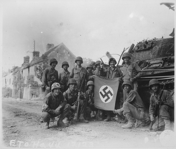 lossy-page1-711px-Lined_up_in_front_of_a_wrecked_German_tank_and_displaying_a_captured_swastika,_is_a_group_of_Yank_infantrymen_who..._-_NARA_-_531503.tif