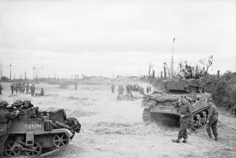 Sherman tanks, carriers and infantry during Operation 'Charnwood', 9 July 1944. Wikipedia