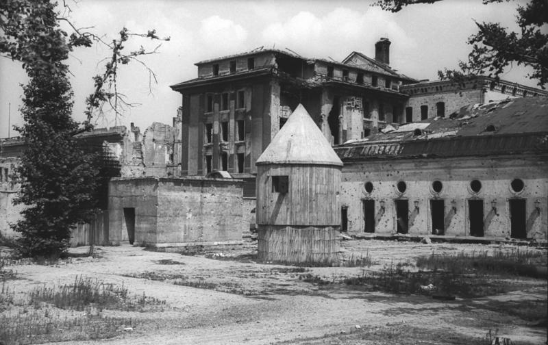 The heavily damaged Reich Chancellery is in the background, the cone on the right is the Ventilation Air Turret, the garden exit is on the left.