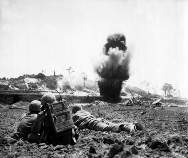 A demolition crew from the 6th Marine Division watch dynamite charges explode and destroy a Japanese cave.  Okinawa, May 1945.  Robert M. Cusack.  (Marine Corps) Exact Date Shot Unknown NARA FILE #:  127-N-122154 WAR & CONFLICT BOOK #:  1227